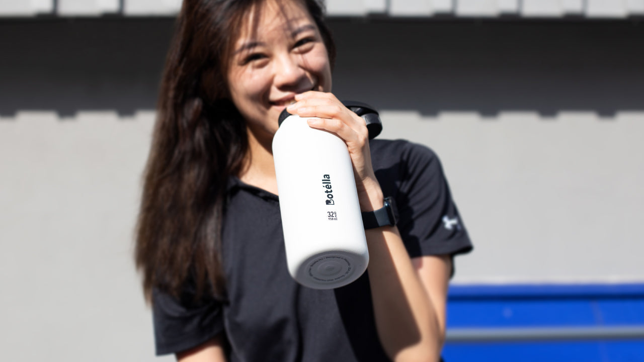A girl holding white color cacuum flask