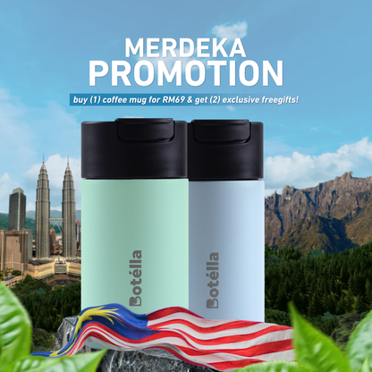 Two Botélla insulated coffee mugs with black lids are shown in a promotional graphic with the text 'MERDEKA PROMOTION' and a Malaysian flag in front, set against a scenic background of the Petronas Towers and mountains.